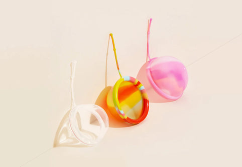 Três cores diferentes de disco menstrual